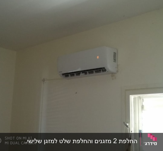 מזגן מותקן על קיר עם תצוגה דולקת